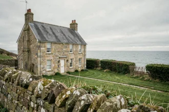 Maison normande en pierre avec vue mer sur la Manche depuis la colline côtière